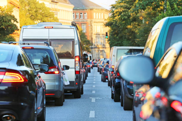 Lång bilkö med tjugotal bilar olika märken som står på rad i en kö och påverka koldioxidutsläpp i Sverige med bilar
